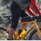 Person riding a bicycle with a focus on cycling gear and equipment.