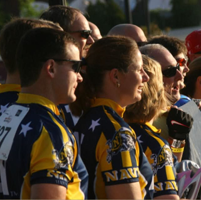 Group of people wearing matching sports jerseys with visible numbers and letters.